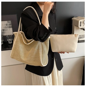 Détail du sac cabas en paille tressée avec bordure crème et pochette zippée assortie