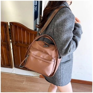 Brown nylon multi-layer crossbody bag worn by a model in a casual daily commute setting