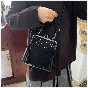 Detailed view of a vintage black fringed crossbody bag with silver kiss-lock and studs