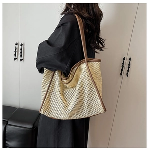 Détail du sac cabas tissé avec anses en cuir marron et texture de maille élégante