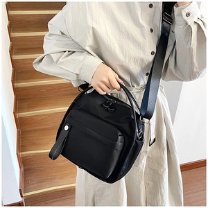 Detail of black nylon crossbody bag with wide strap on light clothing model