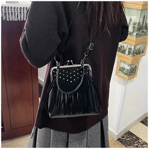 Detail of vintage black fringe bag with silver studs and metal clasp closure