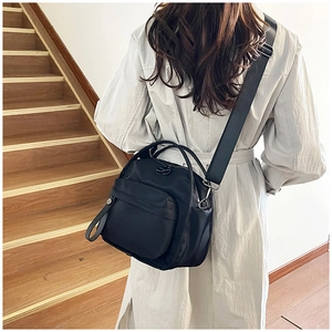 Detail of black nylon crossbody bag with multi-layer pockets and adjustable wide strap