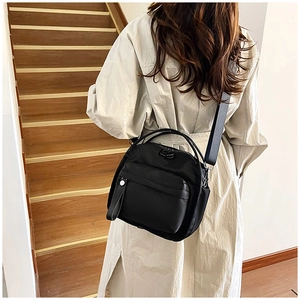 Detailed back view of a black nylon crossbody bag with adjustable wide strap and handle