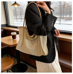 Détail du sac cabas tissé avec bordure en cuir marron et longues poignées de bandoulière