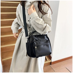 Detail of black waterproof nylon crossbody bag with wide strap and zip pocket