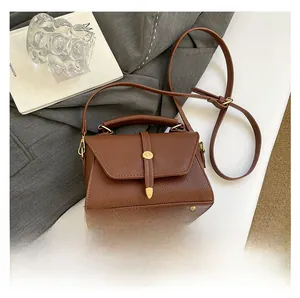 Borsa a trapezio in pelle marrone confrontata con uno smartphone per mostrare le dimensioni