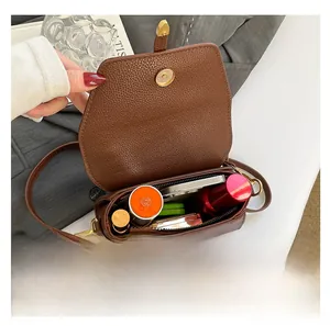 Dettaglio dell'interno di una borsa in pelle marrone con spazio per piccoli accessori