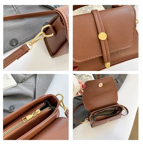 Detail of brown lychee leather bag with gold hardware hooks and metal zipper