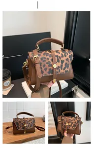 Detail of leopard print flap and metal buckle on brown faux leather crossbody bag