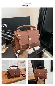 Detail of brown litchi pattern leather bag with golden buckle and adjustable strap