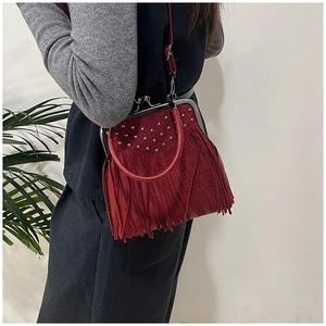 Detail of dark red vintage tassel handbag featuring silver studs and metal clasp closure