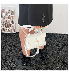 Detail of white lychee leather texture with gold metal buckle on a stylish handbag