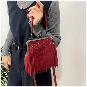 Dettaglio borsa in camoscio bordeaux con frange, rivetti in metallo e telaio vintage