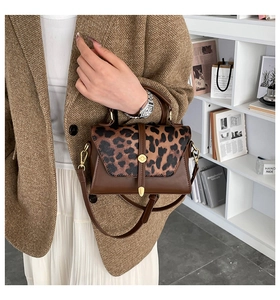 Detail of vintage leopard print bag with gold buckle on a stylish suit outfit