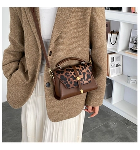 Detail of vintage leopard print crossbody bag styled with a professional wool blazer