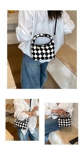 Detail view of black and white checkered woven shoulder bag with dual strap functionality