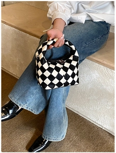 Modern black and white checkered handbag with metal zipper and rounded leather handle