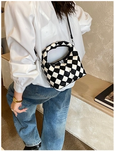 Close-up of a black and white checkered hobo bag with a zipper and metal hardware
