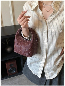 Detail of burgundy woven leather hobo bag with signature knot and litchi texture
