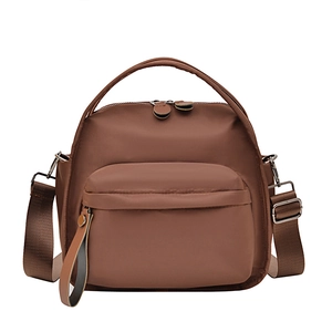 Coffee brown waterproof nylon crossbody shoulder bag with silver zippers on white background