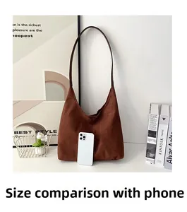 Brown suede hobo tote bag size comparison with a smartphone showing spacious capacity