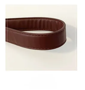 Macro detail of high-quality brown leather tote handle with precision stitching