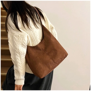 Close-up of vintage brown suede tote bag with visible vertical stitching on the surface