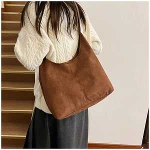 Brown suede tote bag detail showing minimalist stitching and premium matte texture