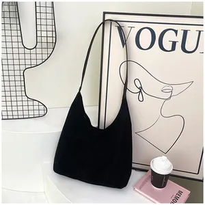 Detail of minimalist black matte tote bag with slim shoulder straps on a decorative background
