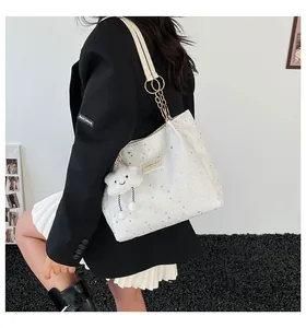 White star print tote bag with chain strap and plush cloud pendant on shoulder