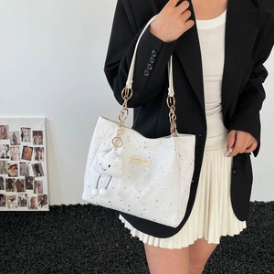 Minimalist white tote bag with silver star pattern and cloud charm shown by model