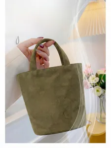 Close-up of olive green suede tote bag showing soft texture and minimalist handle design