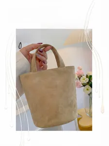Close-up of light brown suede bucket bag texture in a warm interior lifestyle setting