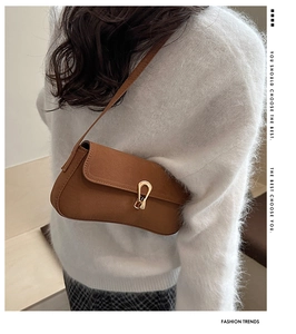 Brown faux leather crescent underarm bag with gold horseshoe buckle on model style