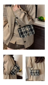 Detail view of black and white plaid crossbody bag with golden S buckle and tassel charm