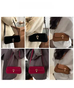 Close-up of matte suede shoulder bags in black, tan and burgundy with gold horse-bit buckles