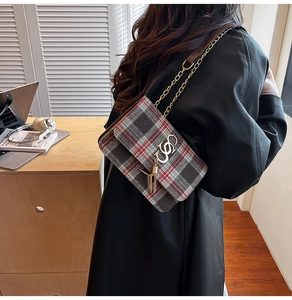 Détail d'un sac à bandoulière en tweed à carreaux rouge et gris avec chaîne dorée