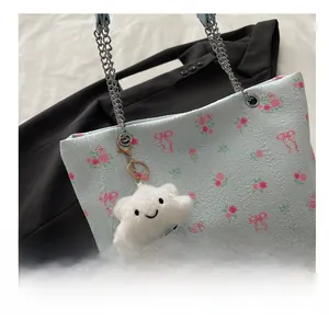 Detail of floral bucket bag featuring pink roses, bow prints, and a cute cloud charm