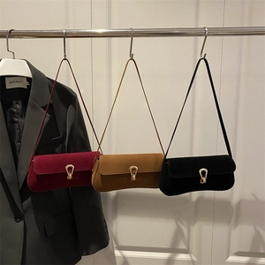 Three minimalist suede shoulder bags in burgundy, camel, and black with gold buckles