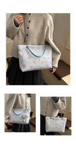 Macro detail of floral jacquard tote with bow pattern and plush cloud charm accessory