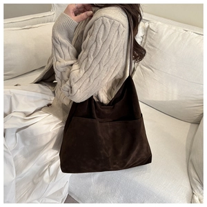 Detail of dark brown matte leather tote bag featuring two large front exterior pockets