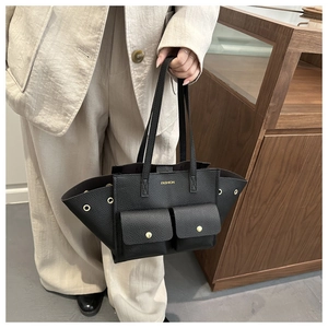 Dettaglio della borsa tote in pelle martellata nera con fibbie dorate e logo stampato