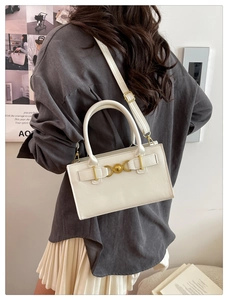 Vista posteriore di una modella con borsa a tracolla bianca minimalista e fibbia a cuore