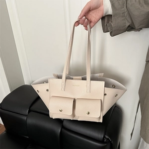 Minimalist beige tote bag with pebbled leather and front flap pockets for daily commute