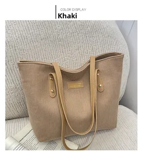 Detail of khaki corduroy tote bag showing textured fabric and leather strap handles