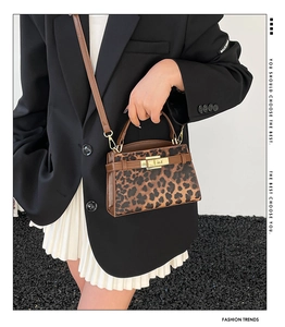 Détail du sac à bandoulière léopard avec boucle dorée et fine bandoulière