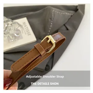 Detail of adjustable brown leather strap with golden metal eyelets and fine stitching