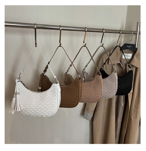 Five assorted colors of pleated half-moon bags with long tassel charms hanging in a row