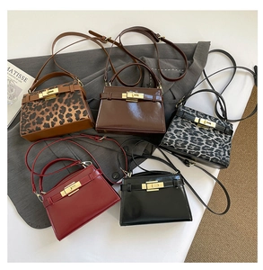 Flat lay of five glossy crossbody bags in leopard print, burgundy, and classic black